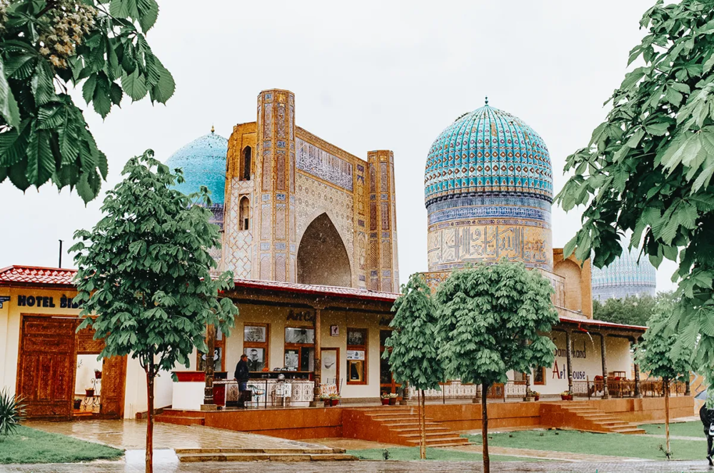 Bibi-Khanym Mosque domes in Samarkand seen from street with trees and buildings
