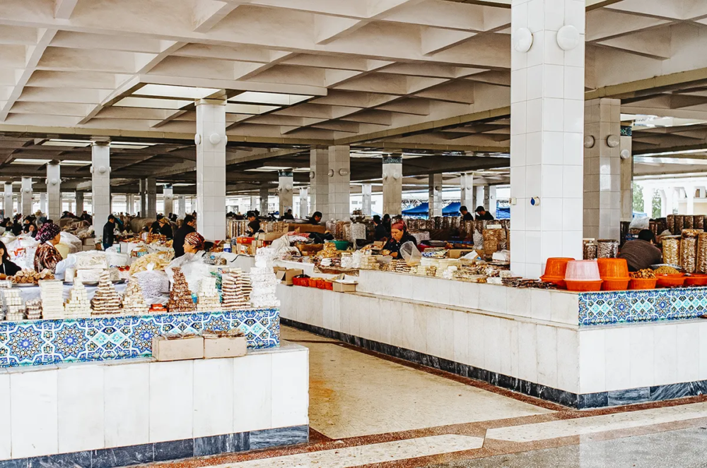 Indoor market at Siyob Bazaar in Samarkand with vendors selling sweets and dried goods